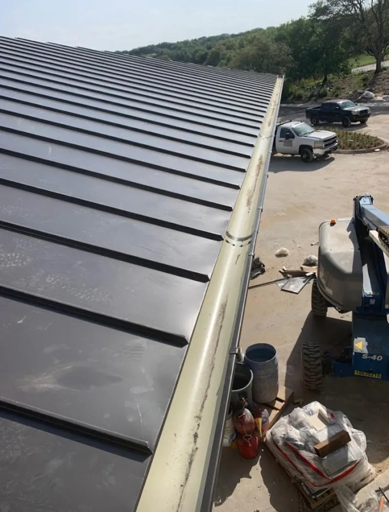 Standing seam panel and gutter detail on a metal roofing jobsite in Cohoes